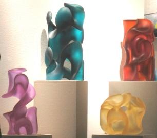 Four contemporary glass sculptures created with sweeping lines, curves and negative space by Harry Pollit, glass artist.  In luminous color, they are hyacinth, jade green, orange red and citrine.