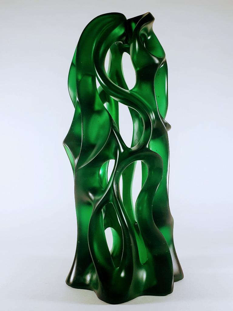 This emerald green cast glass sculpture by Harry Pollitt stands 2'-0" high and 10.5" in diameter.  Its size and complexities of negative space draw you in.